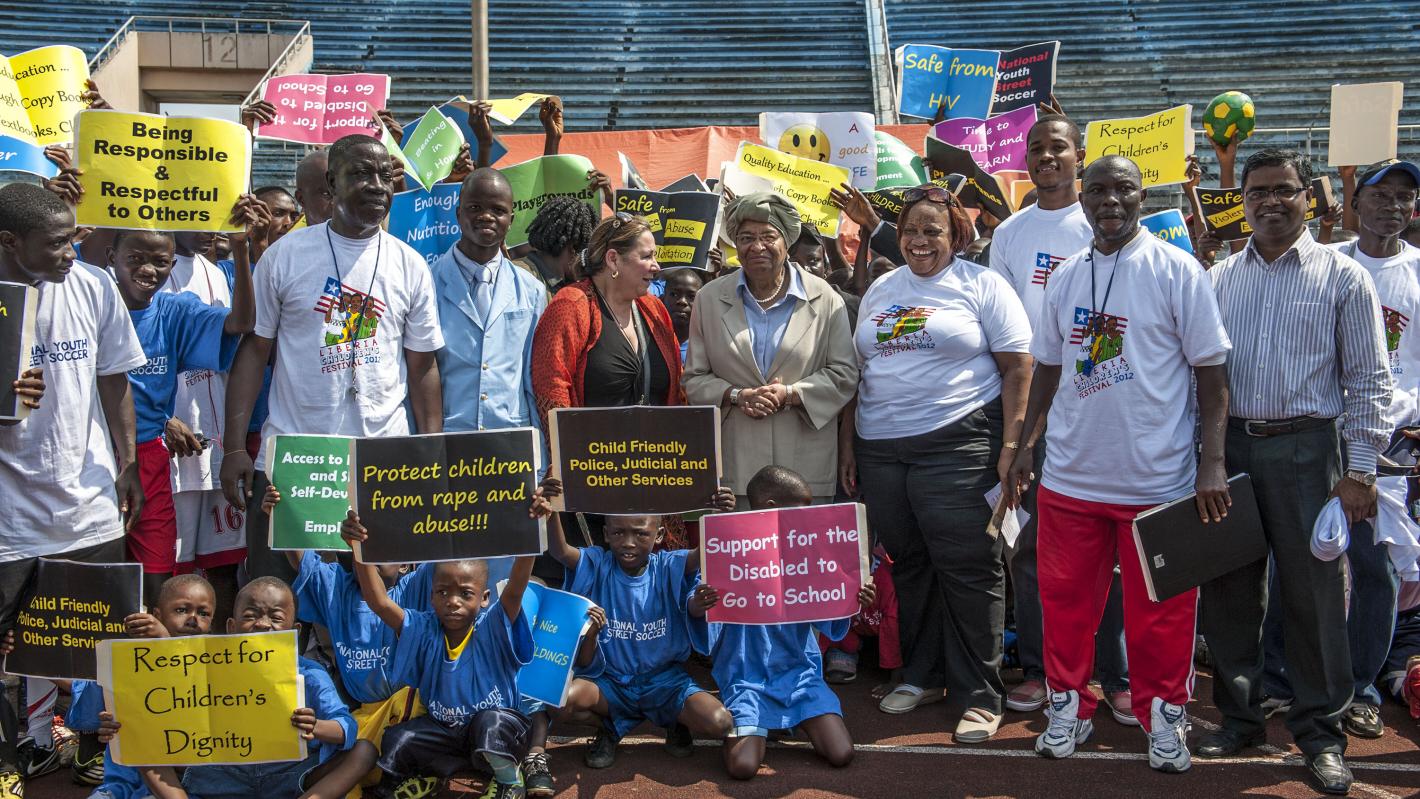 A group of people standing together with signs promoting human rights.