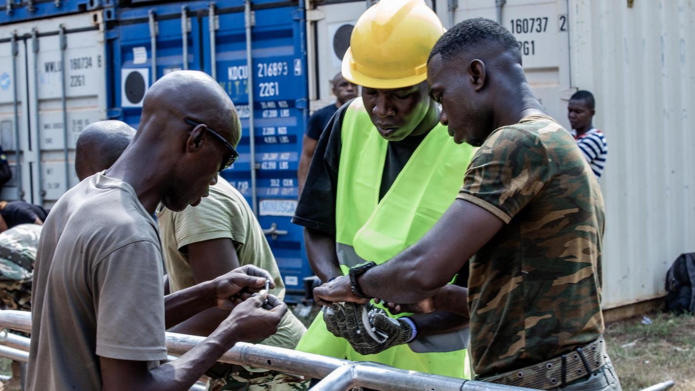 three people making a tent