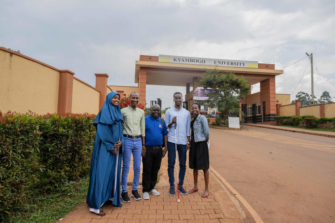 Kyebagadha Binsali, the Head of KyU Hi-Techn Center, and UDHAN team members pose for a group photo at the main gate of KyU in Kampala, Uganda.