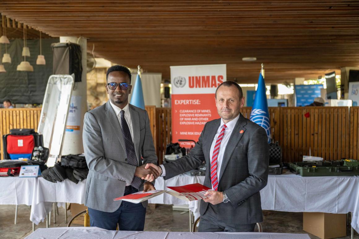 Chief of UNMAS in Somalia Francis O’Grady and State Minister of Defence Omar Ali shake hands after signing documents during a handover event facilitated by UNMAS in Mogadishu.